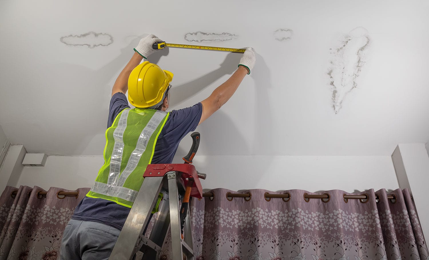 Worker man fixing a leaking pipe in ceiling