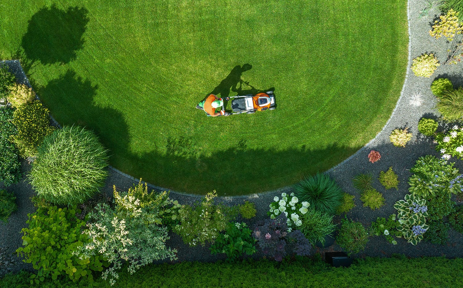 aerial view of a man mowing a well maintained lawn