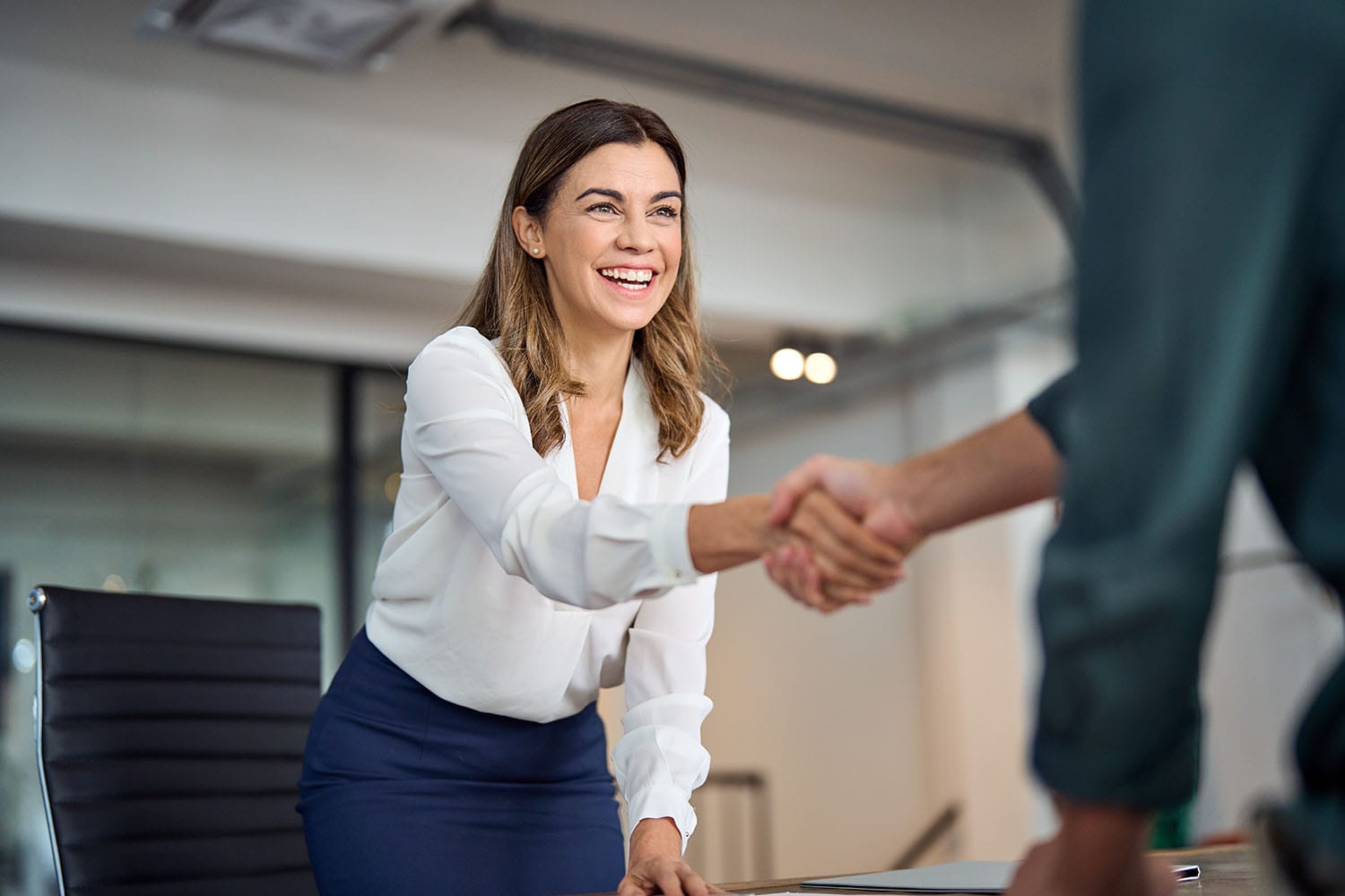 Happy business woman shaking hands with a man