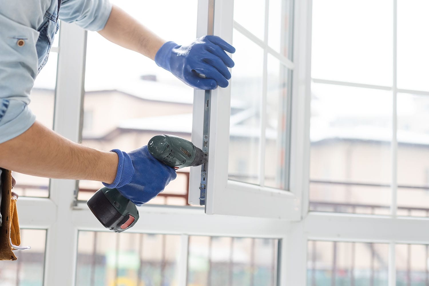 a handyman making adjustments to home windows during a fortification process